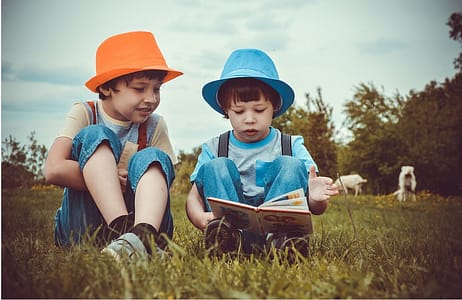 two boys outdors reading